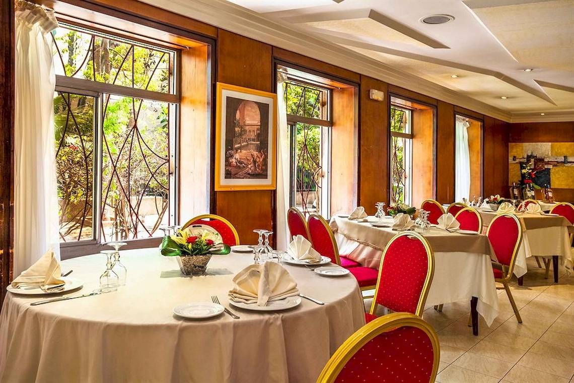 Innenraum des Restaurants im Allegro Agadir Hotel mit gedeckten Tischen und Stühlen.