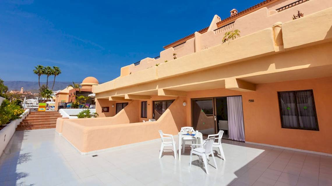 Terrasse des Tagoro Family & Fun Costa Adeje Hotels mit Tisch und Stühlen.