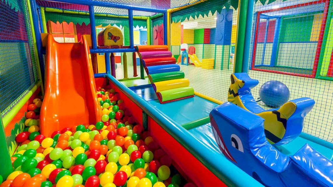 Spielplatz im Tagoro Family & Fun Costa Adeje mit vielen bunten Bällen und einem großen orangefarbenen Rutsch.