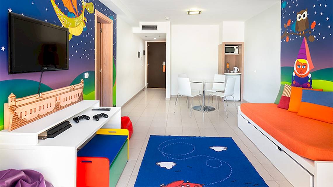 Kinderzimmer im Tagoro Family & Fun Costa Adeje mit bunten Wänden, Fernseher und Spielkonsolen.