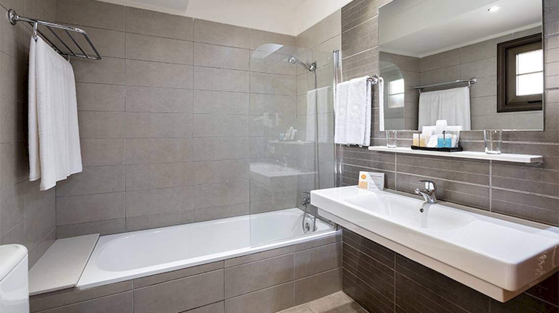Badezimmer im Tagoro Family & Fun Hotel in Costa Adeje mit Badewanne, Dusche, Waschbecken und Toilette.
