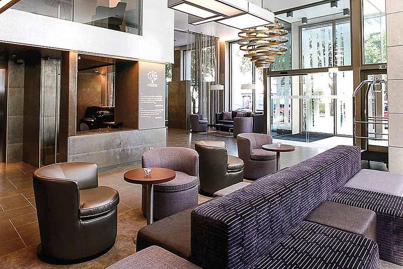 Lobby des Neya Lisboa Hotels mit modernen Möbeln und leuchtenden Lampen.