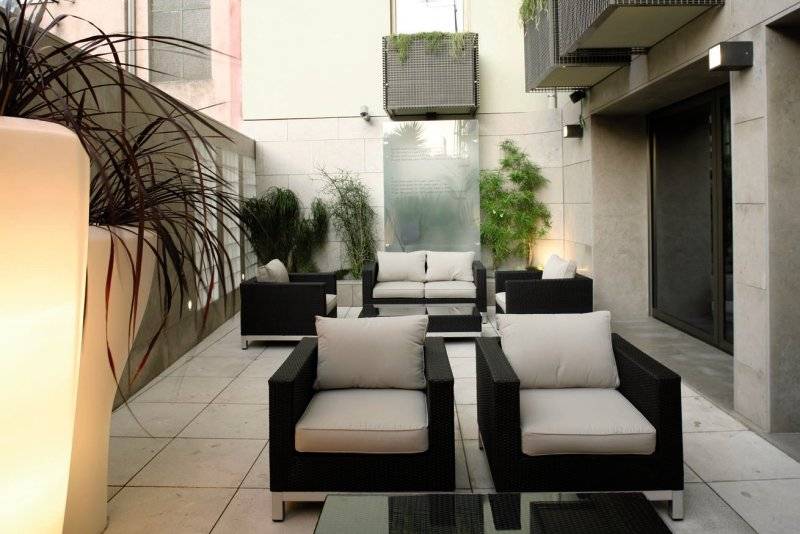 Foto von der Terrasse des Neya Lisboa Hotels mit Sitzecken und Pflanzen.