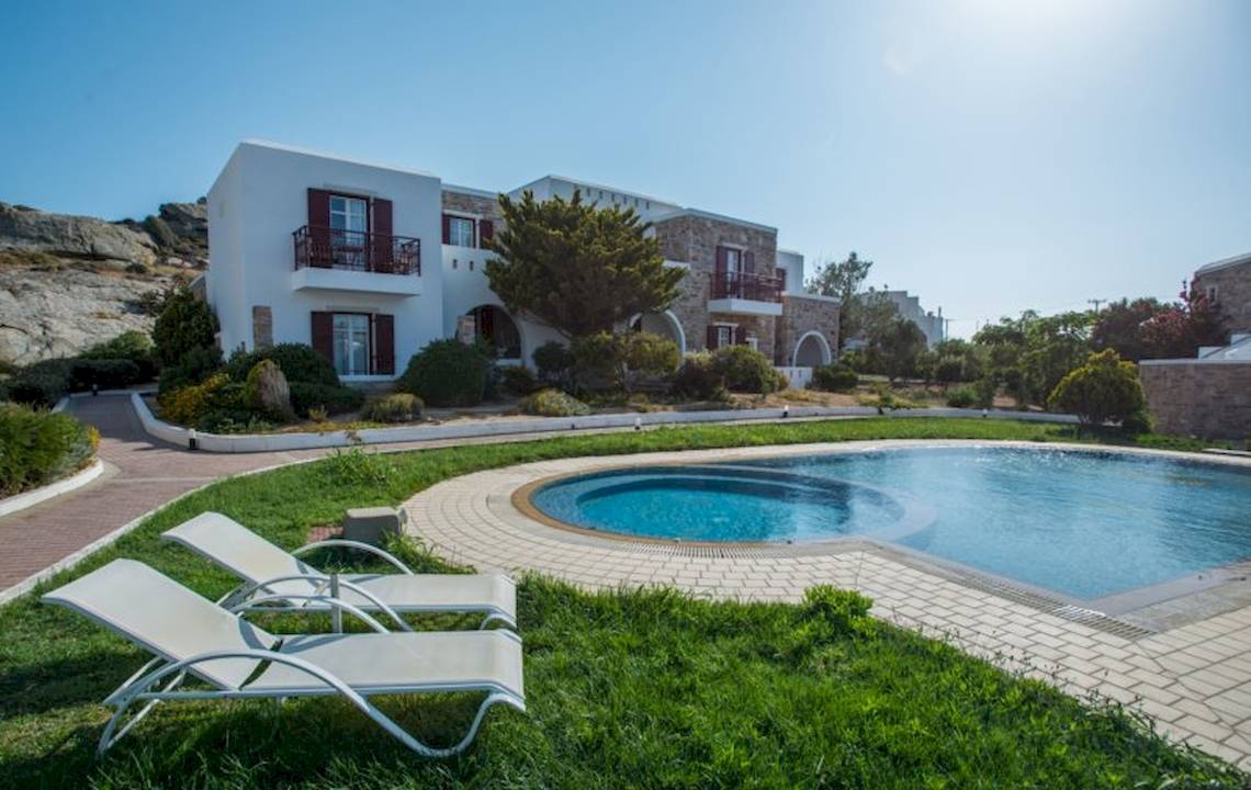 Das Naxos Palace Hotel mit einem Pool und Liegen auf dem Rasen.