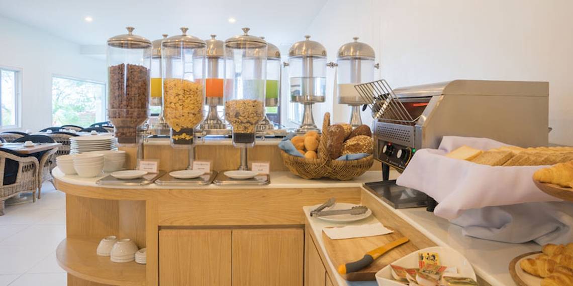 Frühstücksbuffet im Ocean Breeze Resort Khao Lak mit verschiedenen Brotsorten, Gebäck und Cerealien.