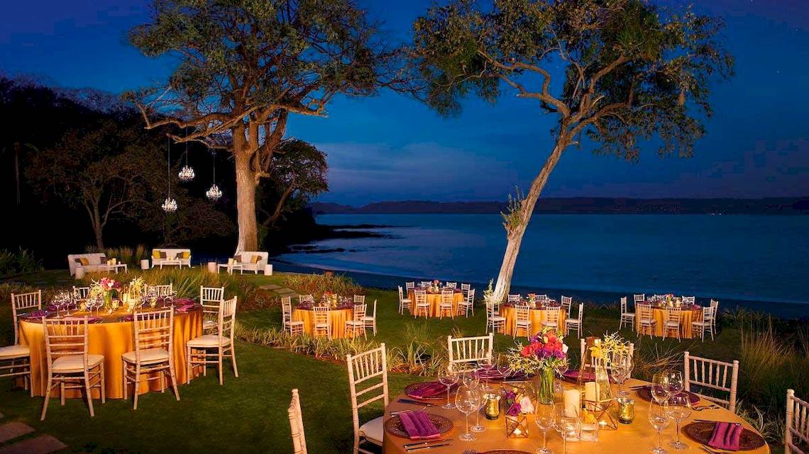 Ein abendessen im freien mit mehreren runden tischen unter freiem himmel am strand des geheimnis papagayo costa rica