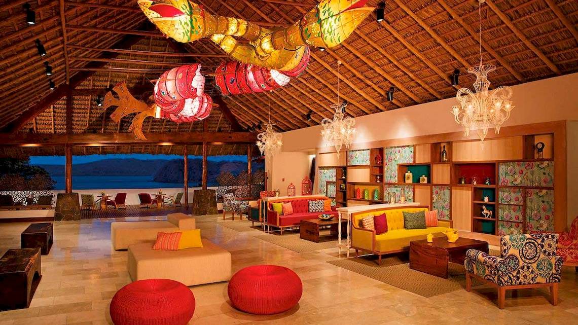 Lobby des Secrets Papagayo Costa Rica Hotels mit bunten Dekorelementen und modernen Möbeln.