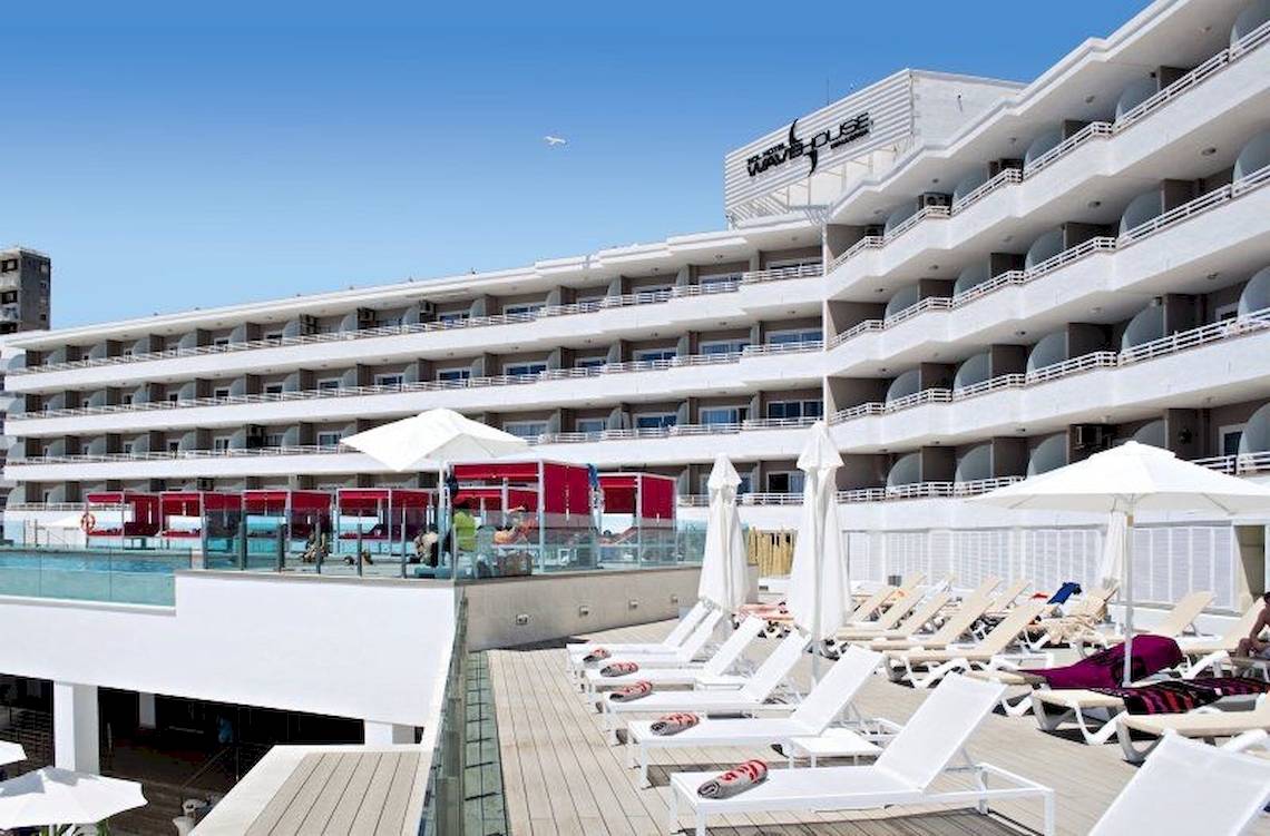 Außenansicht des Sol Wave House All Suites Hotels mit Pool und Liegestühlen.