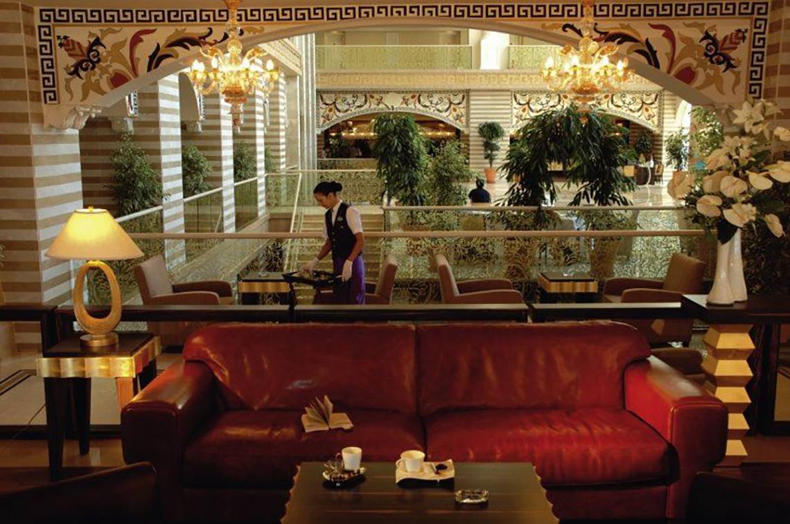 Lobby-Lounge mit roter Couch und Lampen im Nirvana Dolce Vita Hotel.