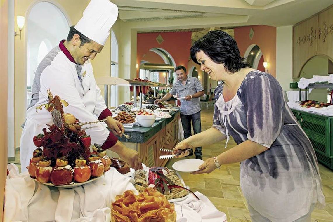 Im Mahdia Beach & Aqua Park Hotel serviert ein Koch ein Buffet mit verschiedenen Gerichten.