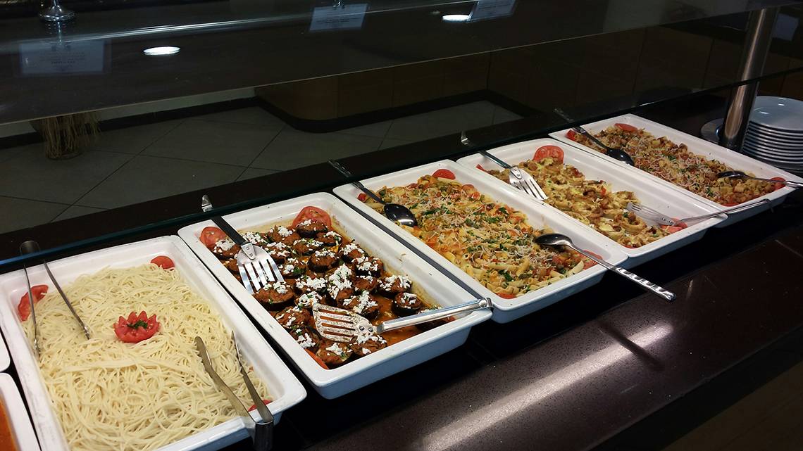 Mehrere Speisen in weißen Schalen auf einem Buffet im Europa Beach Hotel & Spa.