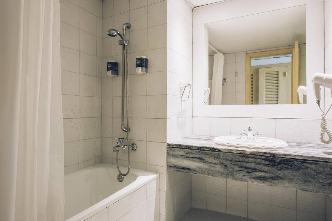 Badezimmer im Iberostar Origin Bella Costa Hotel mit Badewanne, Spiegel und Föhn