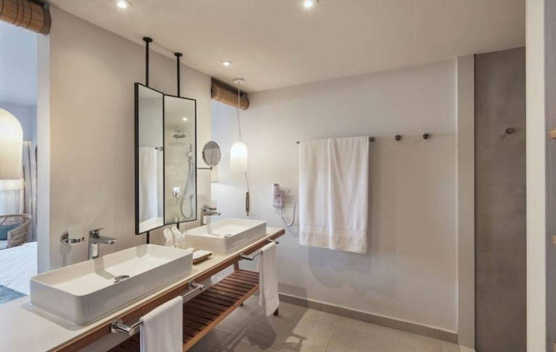 Badezimmer im Preskil Island Resort mit zwei Waschbecken, Spiegeln und Handtüchern.