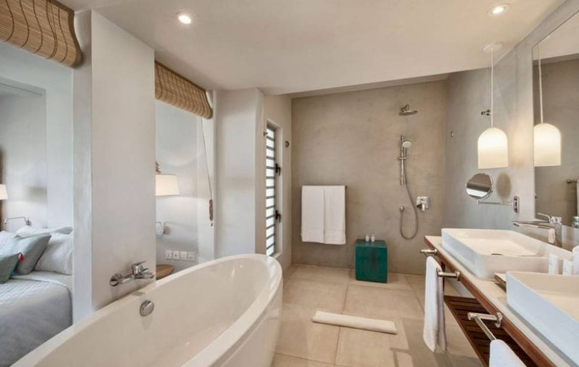 Badezimmer im Preskil Island Resort mit Badewanne, Dusche und Doppelwaschbecken.