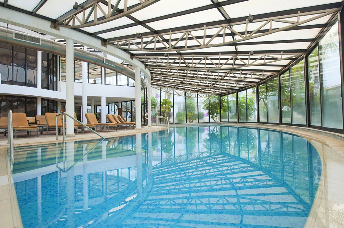 Innenpool des Louis Ledra Beach Hotels mit blauem Wasser und Glasdach