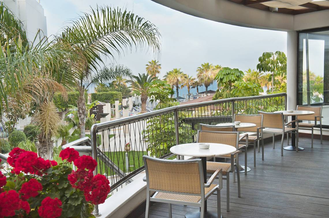 Hotelterrasse mit Blick auf Palmen und das Meer im Louis Ledra Beach.