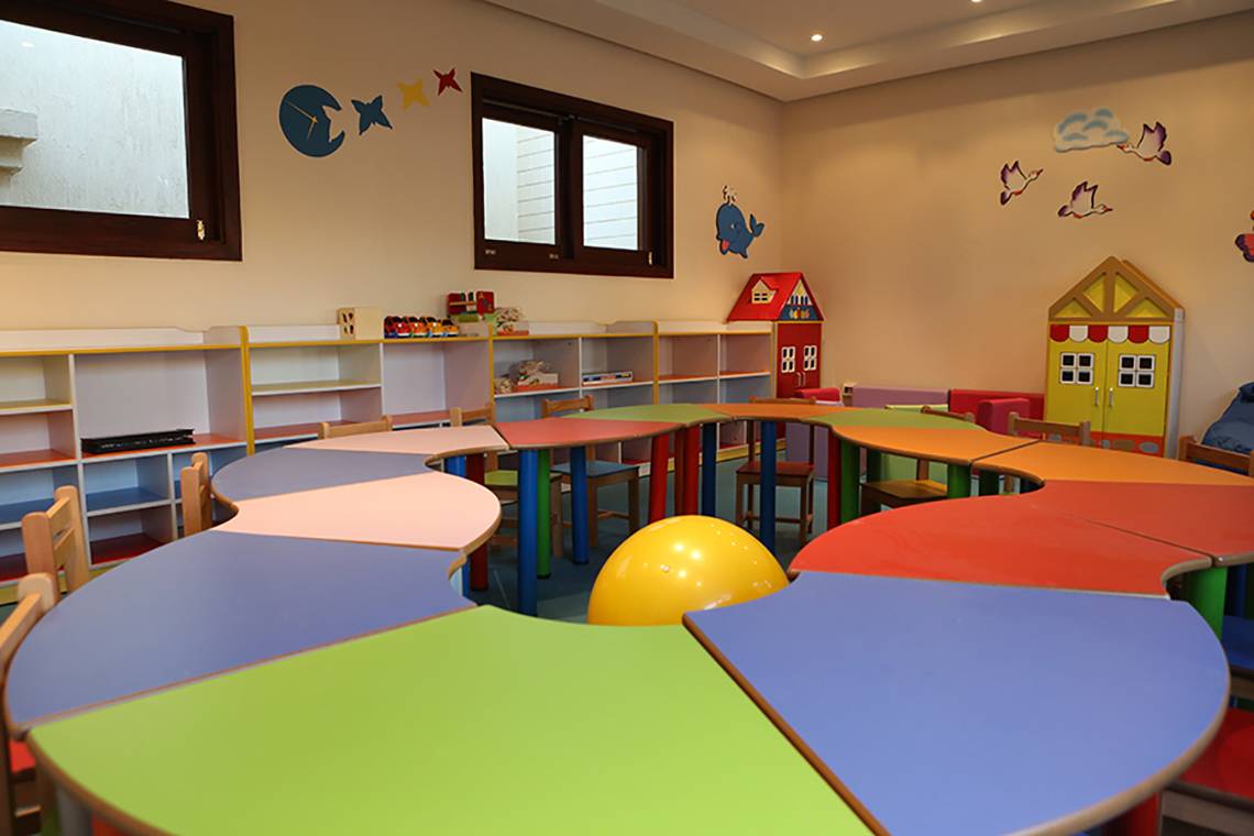Kinderzimmer im Rixos Sharm El Sheikh mit bunten Tischen, Stühlen und Spielzeug.