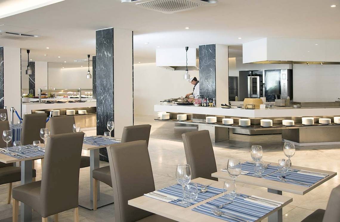 Innenansicht des Alua Leo Hotels mit Restaurant und Tischen, Stühlen und Geschirr.
