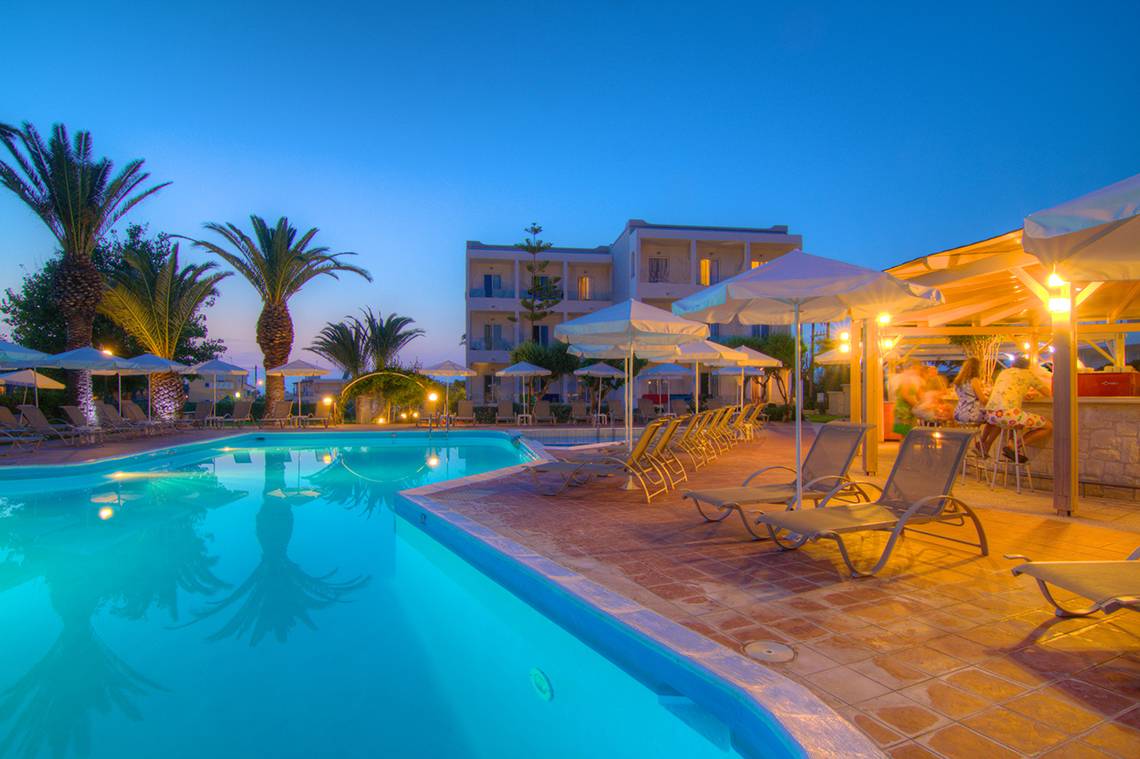 Ein Poolbereich des Solimar Dias Hotels bei Nacht mit Loungeliegen und Palmen.