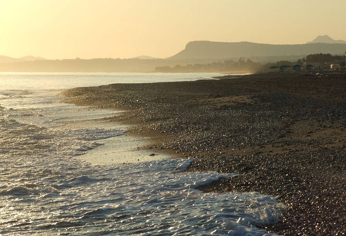 Sonnenuntergang am Strand von Solimar Dias mit Wellen, die auf den Kiesstrand treffen.