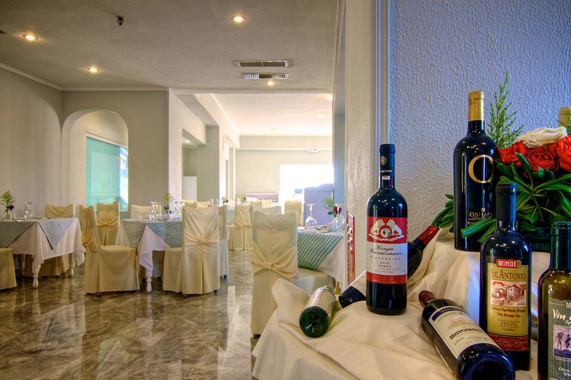 Ein Saal im Hotel Solimar Dias mit gedeckten Tischen und Flaschen.
