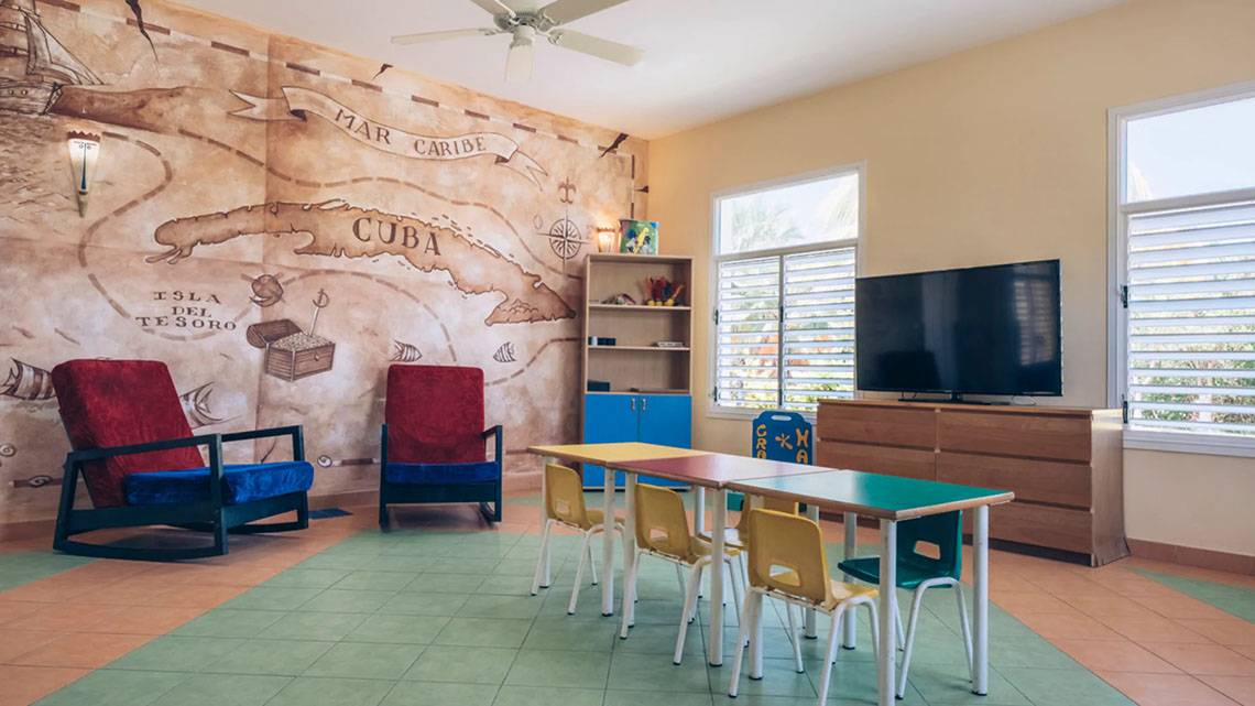 Kinderzimmer im Iberostar Laguna Azul Hotel mit einem großen Wandbild von Kuba und einem Fernseher.
