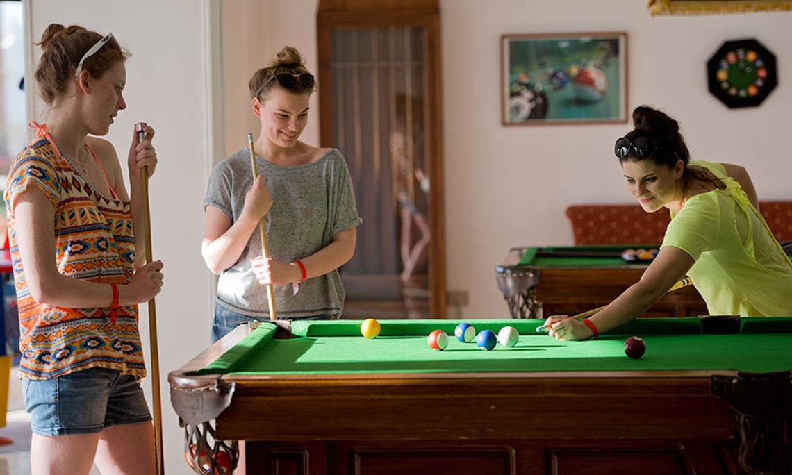 Drei Frauen spielen Billard im Amphoras Beach Hotel.