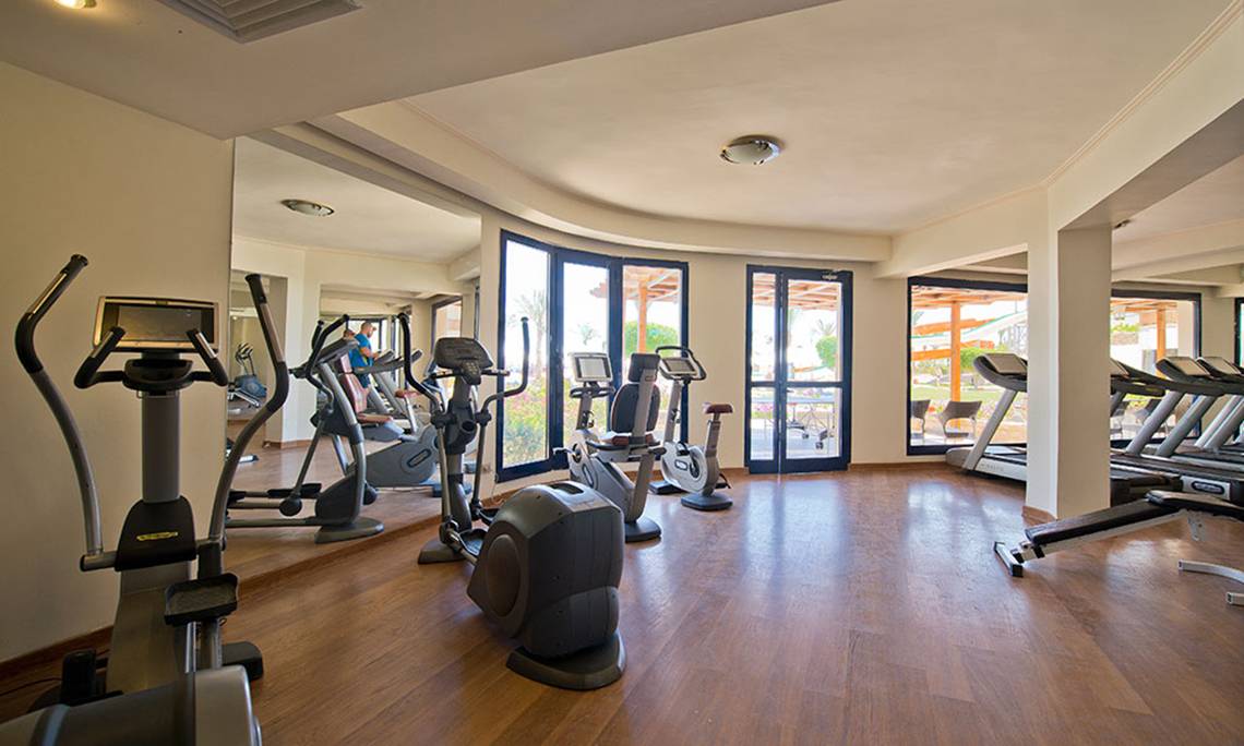 Fitnessstudio im Amphoras Beach Hotel mit verschiedenen Trainingsgeräten und großen Fenstern