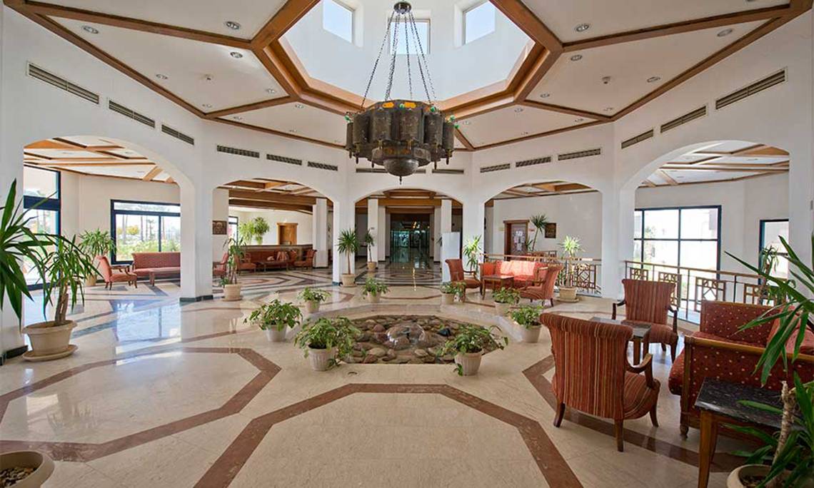 Lobby des Amphoras Beach Hotels mit Innenhof, Brunnen, Möbeln und Pflanzen.