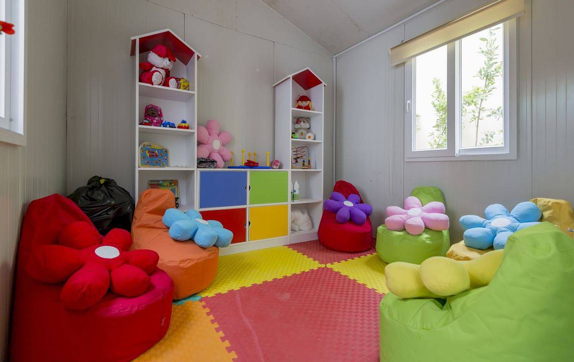 Kinderzimmer im Side Royal Palace Hotel & Spa mit bunten Kissen und Spielzeugregalen.