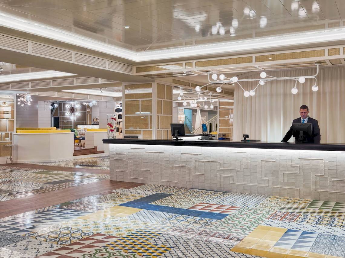 Empfangsbereich des H10 Las Palmeras Hotels mit geometrischem Bodenmuster und modernen Möbeln.