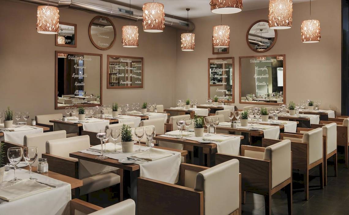 Foto des Innenbereichs des Restaurants im H10 Las Palmeras Hotel mit elegant eingerichteten Tischen und Stühlen.