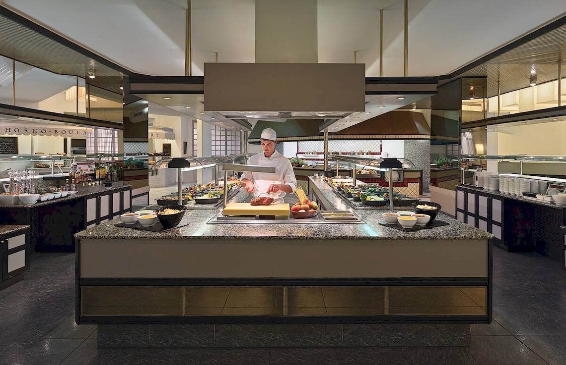 Im Restaurant H10 Las Palmeras bereitet ein Koch ein Buffet zu.