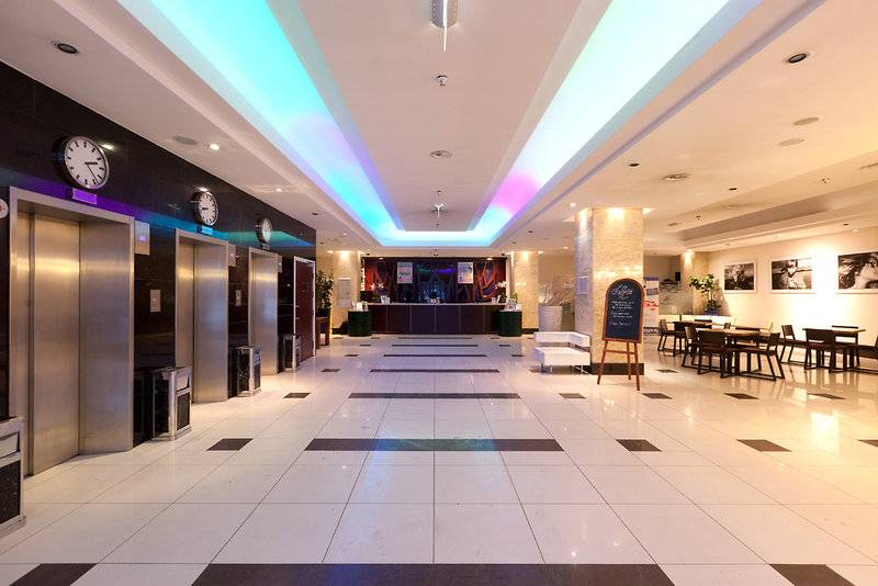 XO Hotels Blue Tower Lobby mit weißen Fliesen und bunten Lichtern