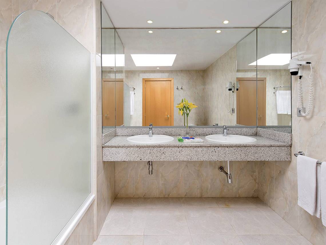 Badezimmer im Tabaiba Princess Hotel mit zwei Waschbecken, Spiegeln und Dusche.
