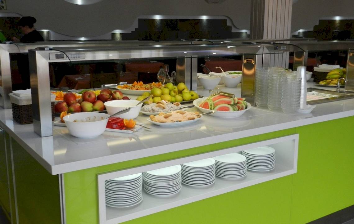 Buffet-Tisch im Turbo Club Hotel mit verschiedenen Obstsalaten, Desserts und Getränken.