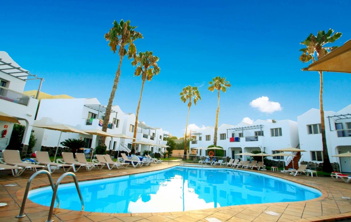 Poolbereich des Turbo Club Hotels mit weißen Gebäuden und Liegestühlen