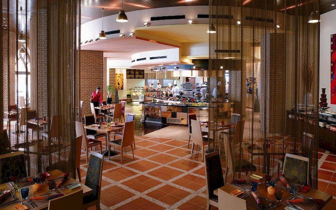 Innenansicht des Restaurants im Shangri-La Barr Al Jissah Resort & Spa mit gefliestem Boden und gedeckten Tischen.