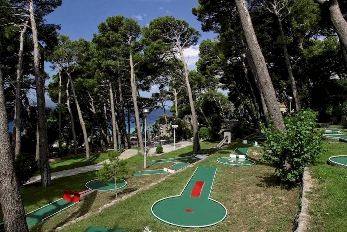 Minigolfplatz im BlueSun Hotel Berulia, umgeben von Bäumen und mit Blick auf das Meer.