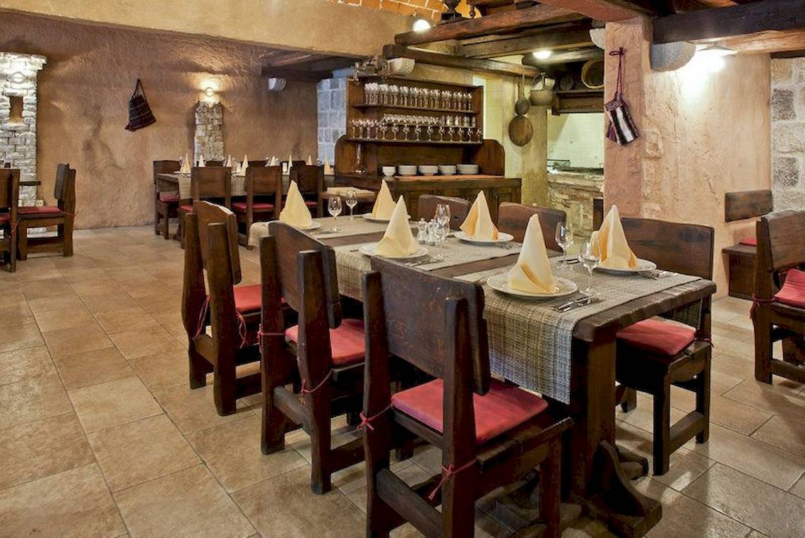 Ein Restauranttisch im BlueSun Hotel Berulia, gedeckt mit Tellern, Gläsern und Servietten.