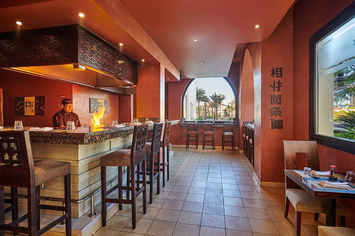 Im Hotel Steigenberger Aqua Magic zeigt sich die Bar-Szene mit einem Koch am Grill und mehreren Barhockern.