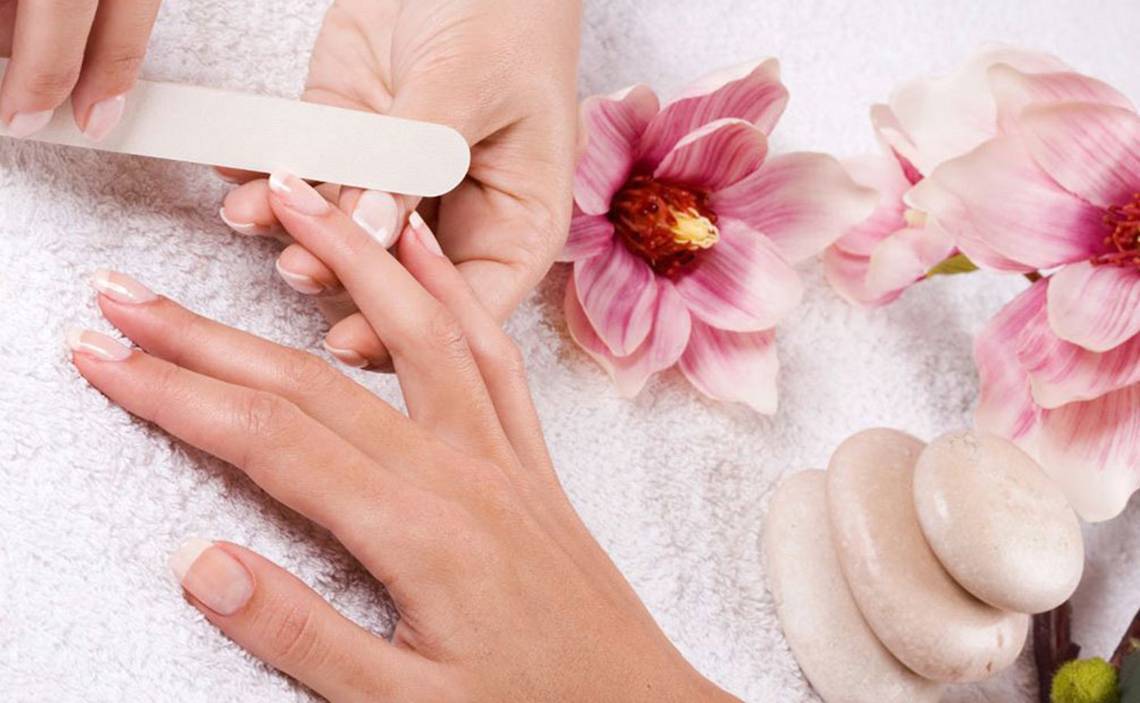 Nagelpflege im Hotel Steigenberger Aqua Magic mit rosa Blumen und Steinen im Hintergrund.