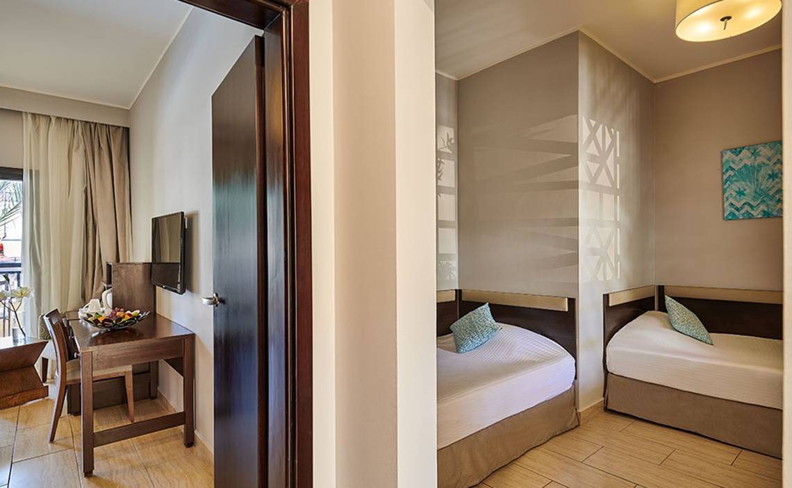 Doppelzimmer im Steigenberger Aqua Magic Hotel mit zwei Betten, Tisch und Fernseher.