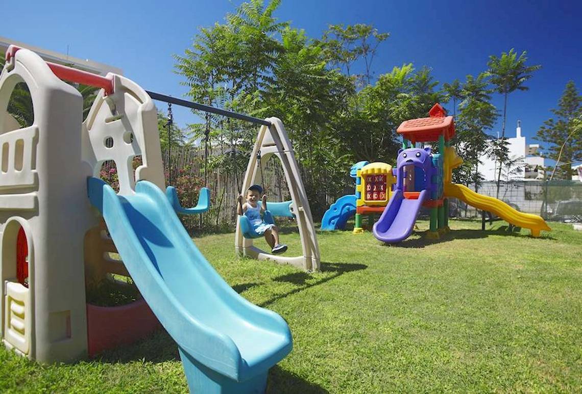 Kinderspielplatz im Atlantis Beach Hotel auf Kreta mit Rutschen und Schaukeln.