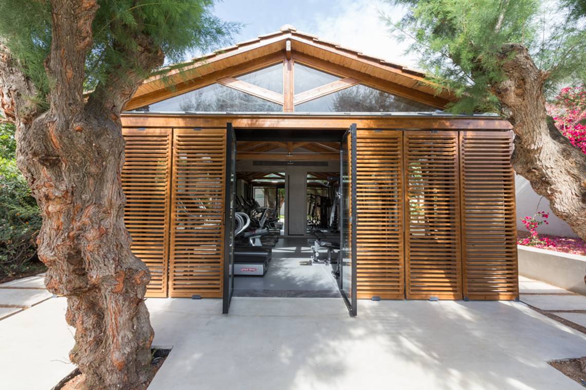 Außenansicht des Fitness Centers des Cretan Malia Park Hotels mit hölzernen Fenstern und Türen