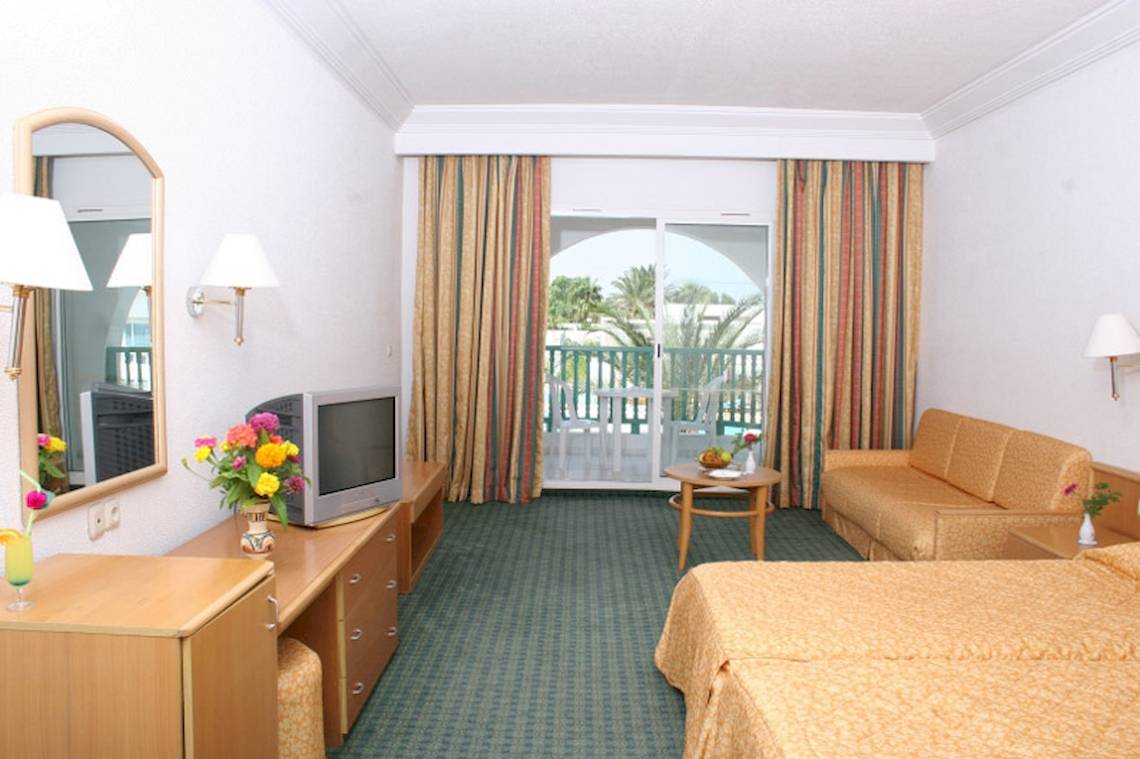 Hotelzimmer im El Mouradi Skanes mit zwei Betten, Fernseher, Couch und Balkon