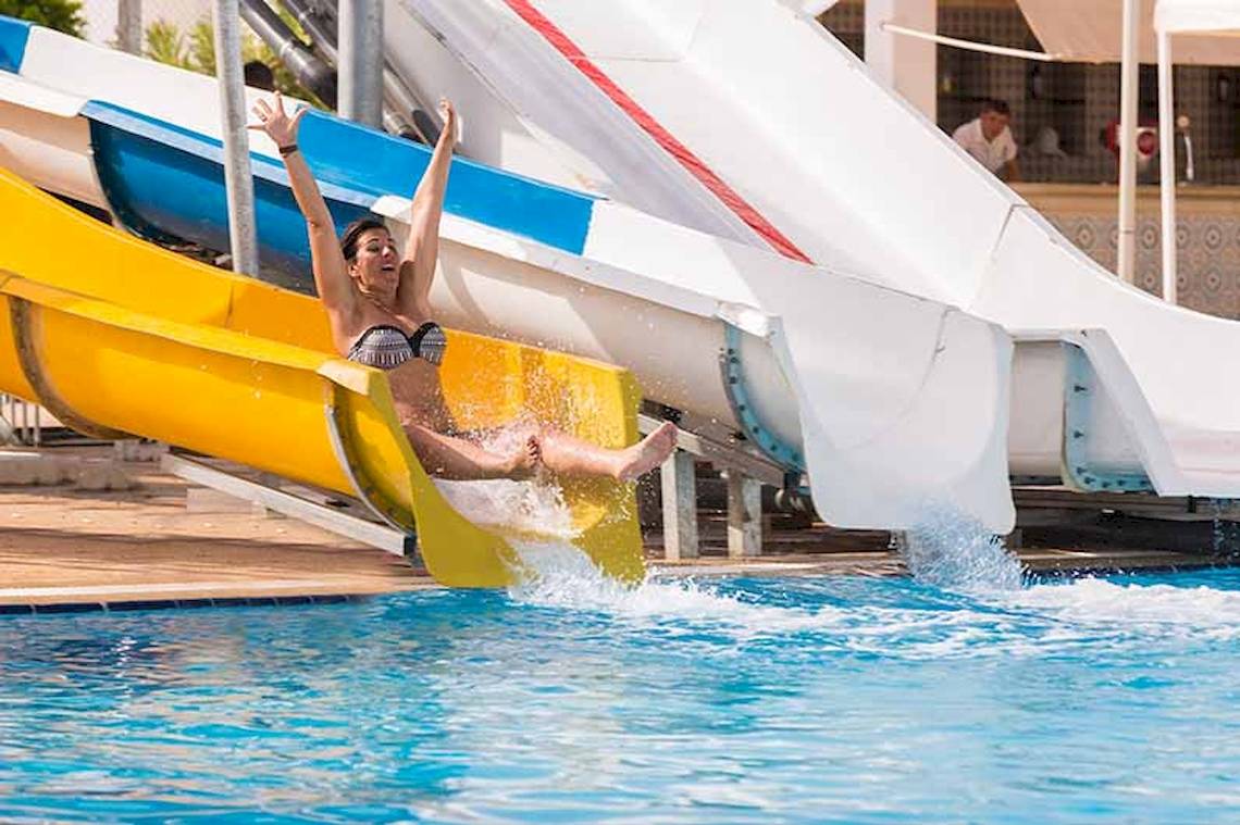 Frau rutscht auf einer gelben Wasserrutsche im El Mouradi Skanes Hotel