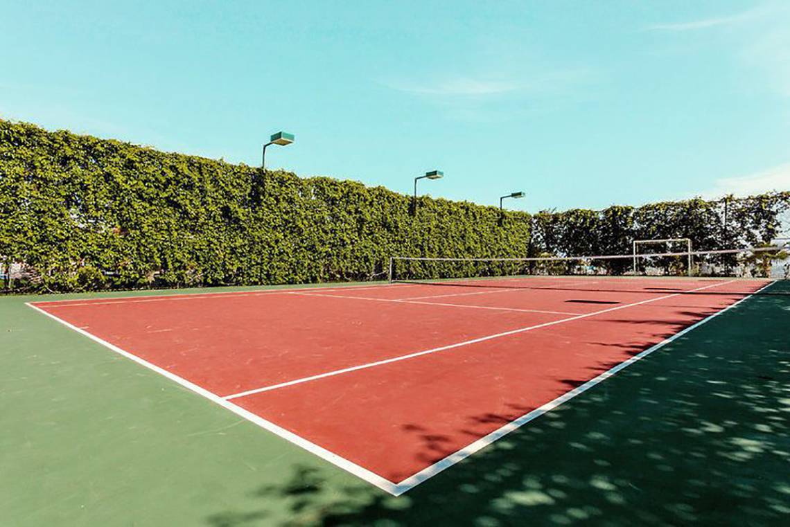 Tennisplatz im Turan Prince Hotel mit rotem Boden und weißen Linien.