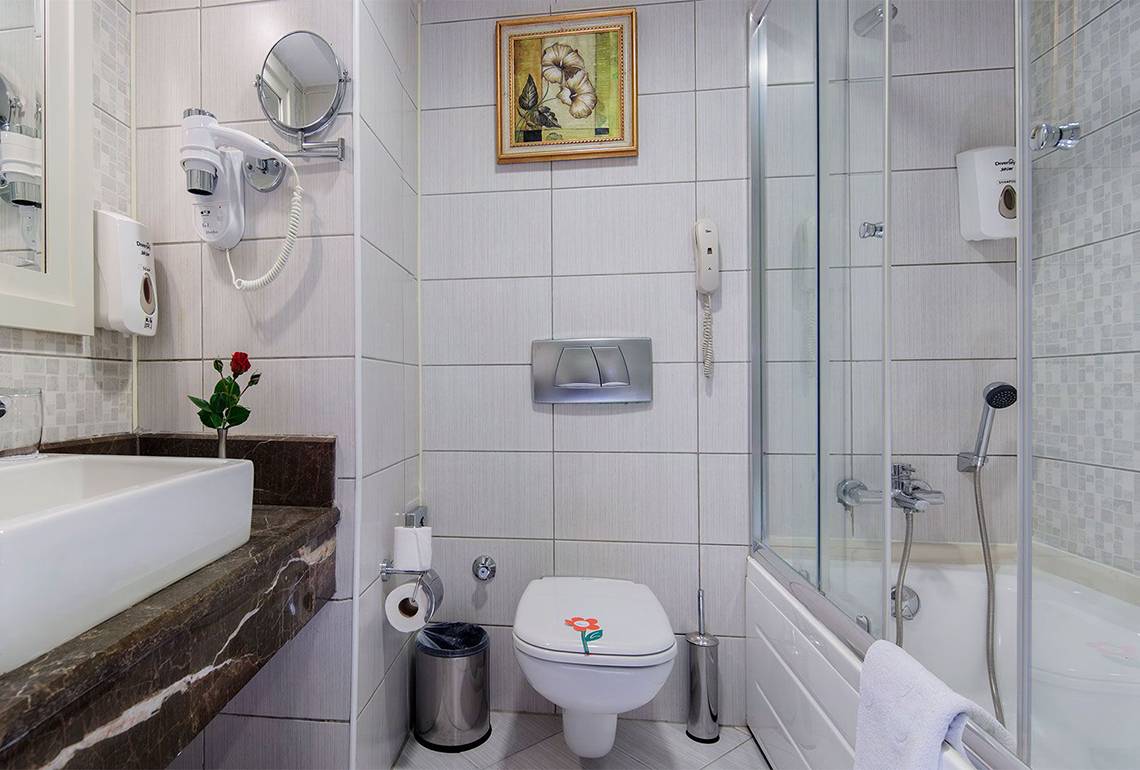 Badezimmer im Alba Queen Hotel mit Badewanne, Toilette, Waschbecken und Dekoration