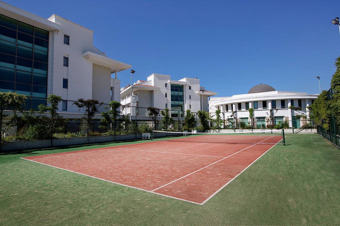 Tennisplatz vor dem Alba Queen Hotel, Gebäude im Hintergrund, sonniger Tag